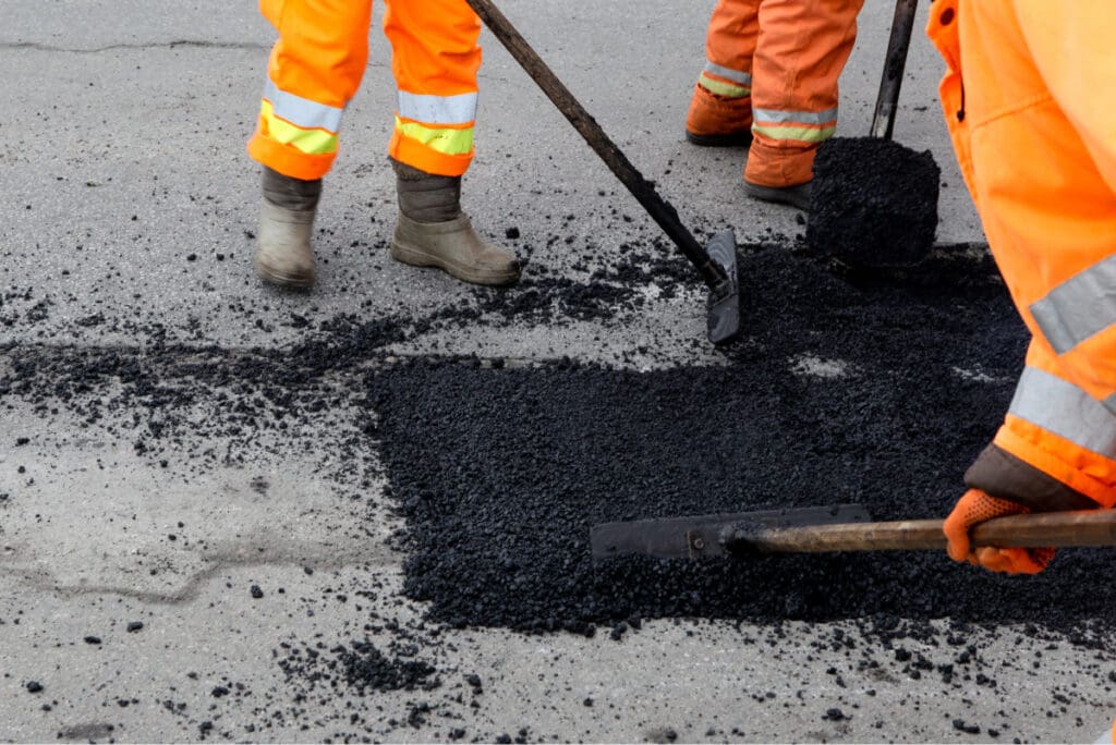 applying asphalt patching material to pothole