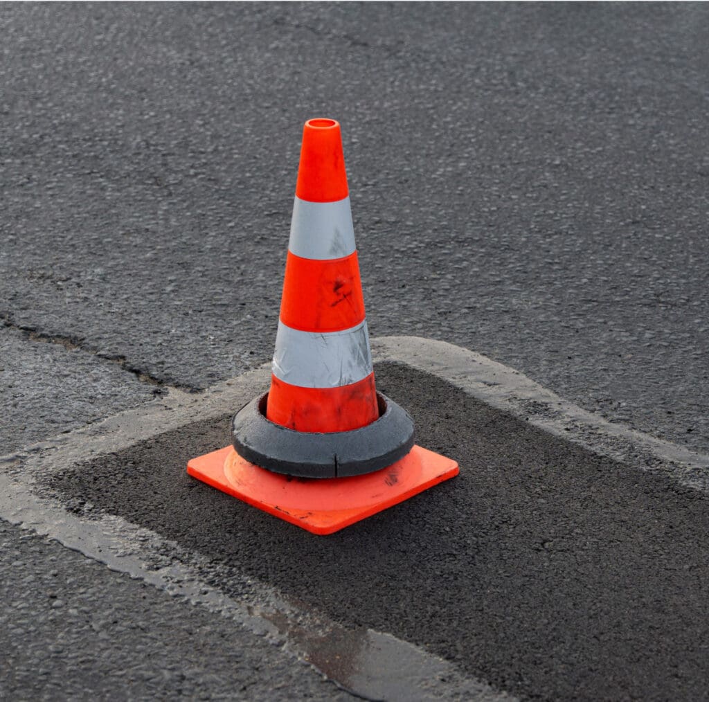 traffic cone on top of pothole repair