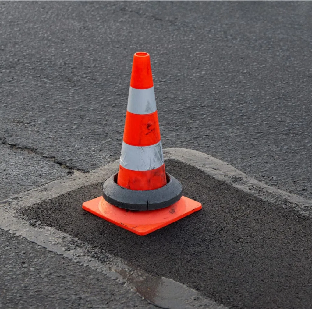traffic cone on top of pothole repair