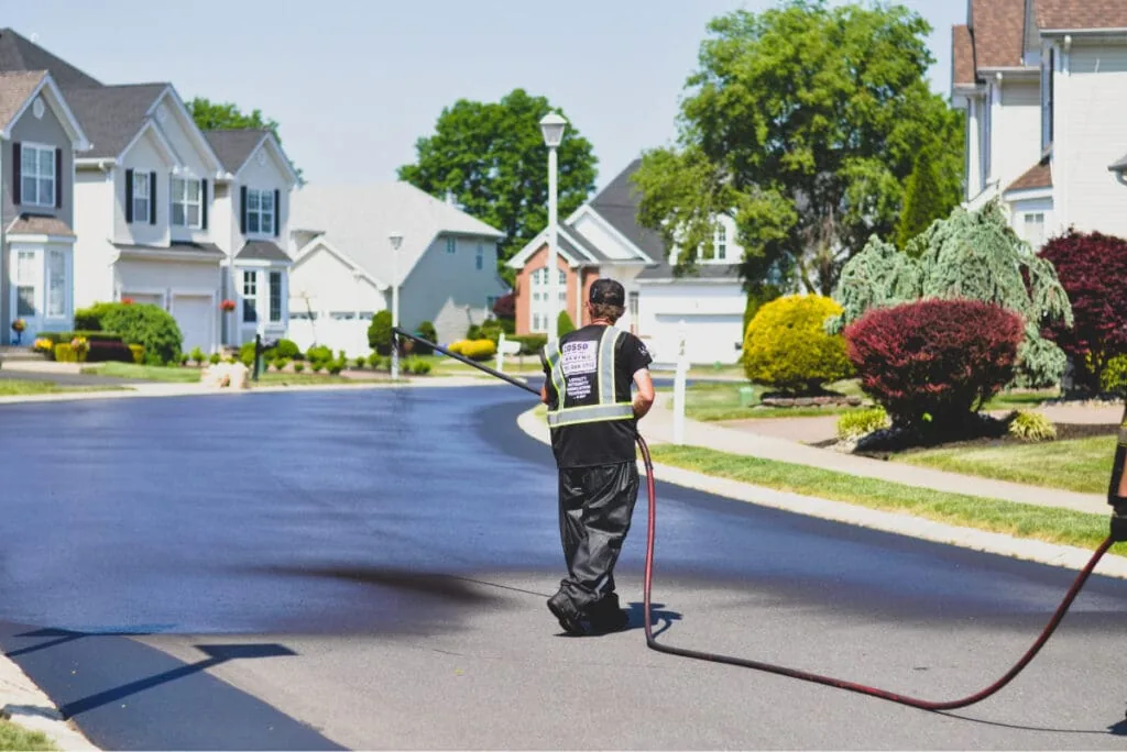 pave america employee applying seal coat to a street