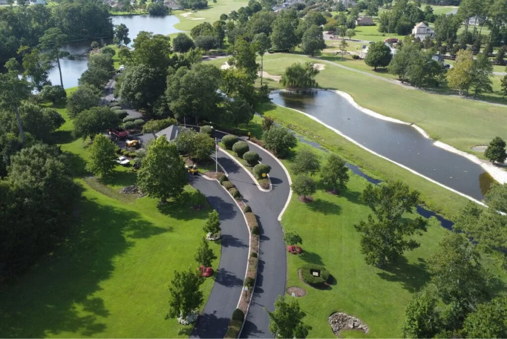 aerial view of a street, lakes, and green grass & trees
