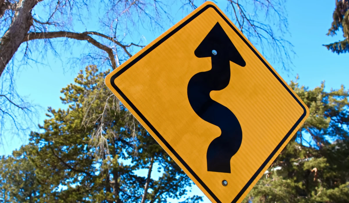 yellow winding road sign