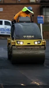 pave america employee on an asphalt roller