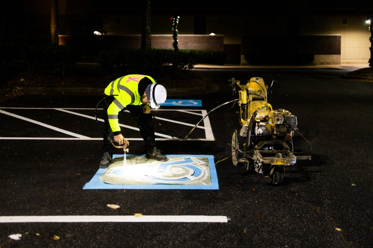 pave america employee painting a handicapped parking spot 