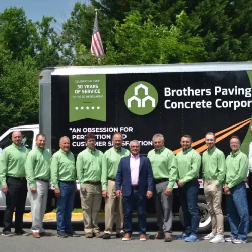 Group photo of Brothers Paving & Concrete in front of company truck.