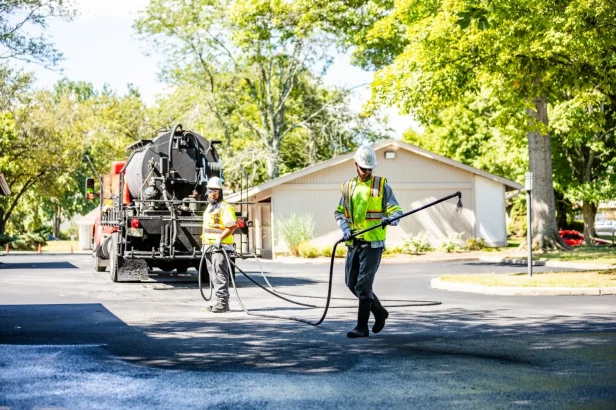 two chamberlain employees sealcoating a street