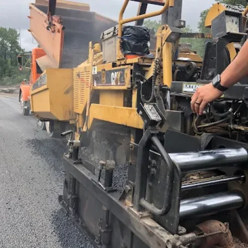 California Asphalt employee on CAT machine on site at commercial paving job.