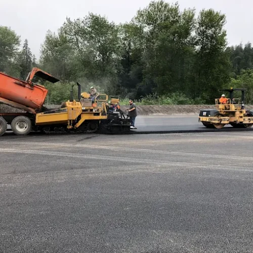 California Asphalt employee on CAT machine on site at commercial paving job.
