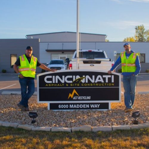 Two employees standing outside of the Cincinnati Asphalt headquarters.