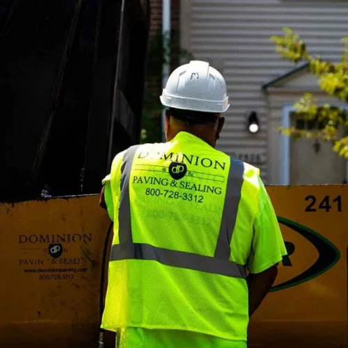 Dominion Paving employee from behind with company logo on his safety vest.