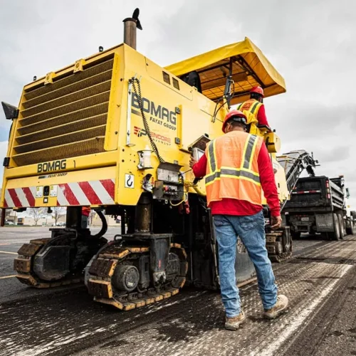 Encore Pavement employee in front of machine.