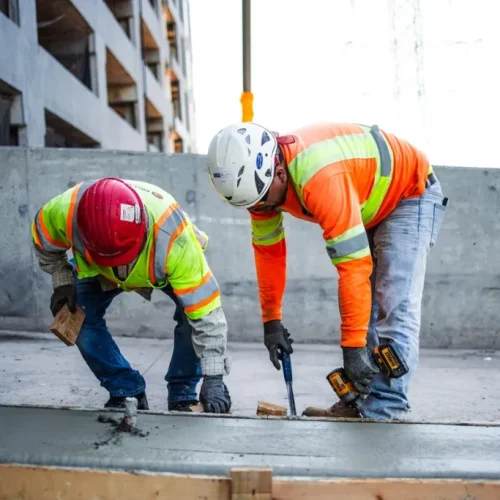 Pave America employees on commercial job site smoothing concrete.