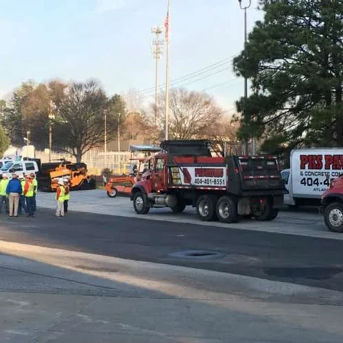 PKS Paving employees and trucks at commercial job site.