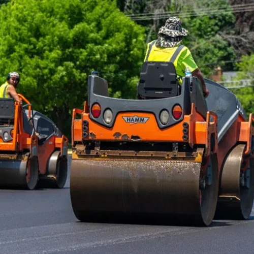 PLM Paving & Concrete employees flattening asphalt.