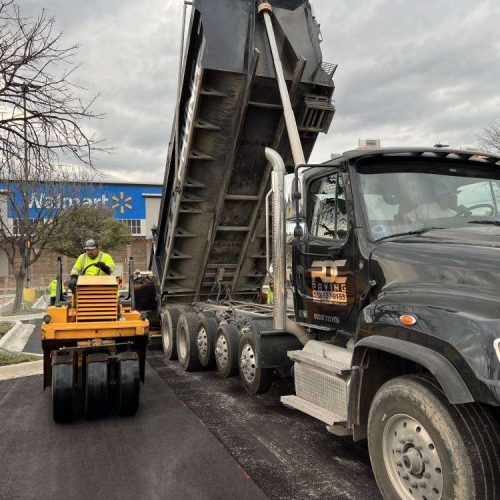 RDC Paving truck with employee on equipment.