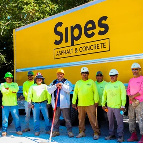 Sipes Asphalt Solutions employees in front of building with company name.