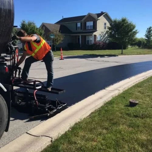 Sipes Asphalt Solutions employee on back of truck