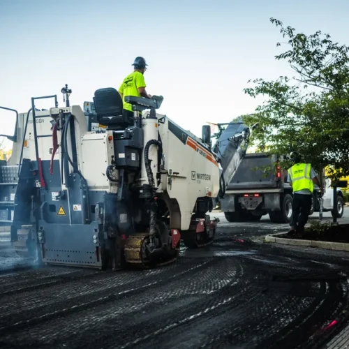 US Pavement Services employee working on top of equipment.