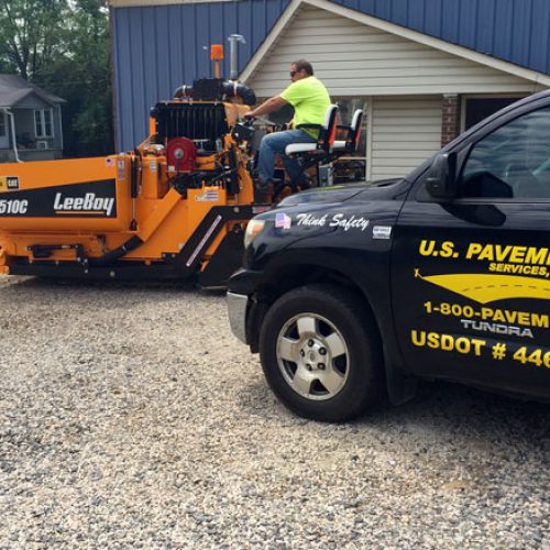 US Pavement Services truck with employee on equipment.