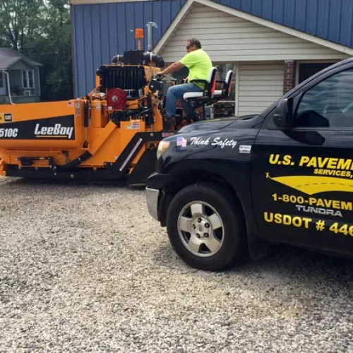 US Pavement Services truck with employee on equipment.