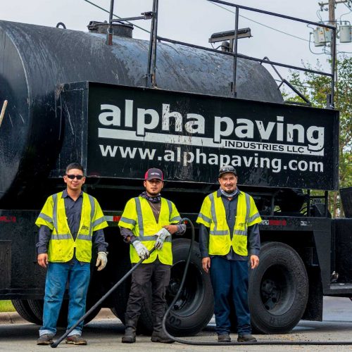 alpha paving employees standing in front of a truck