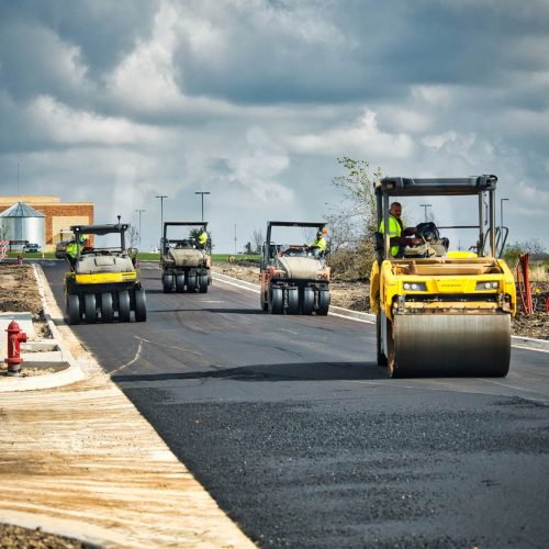 Alpha paving employees on asphalt rollers