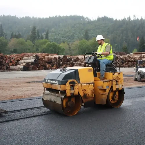 Kansas Asphalt employee on machine at commercial paving jobsite.