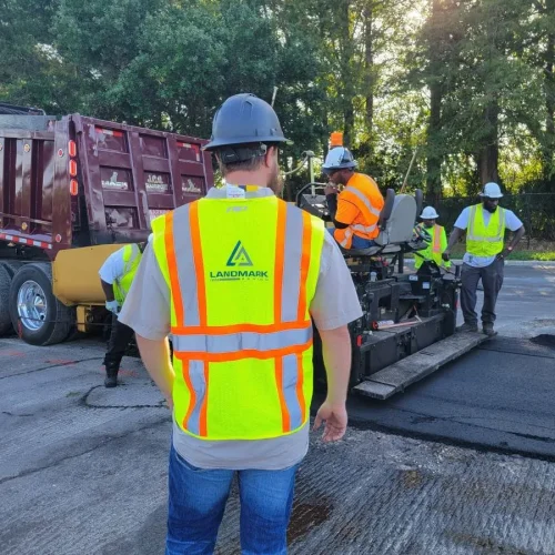 the back of a landmark paving employee with a construction vest on