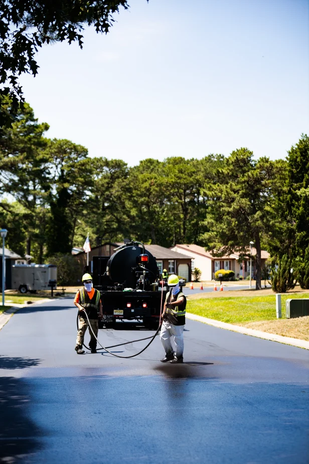 pave america employees sealcoating a street